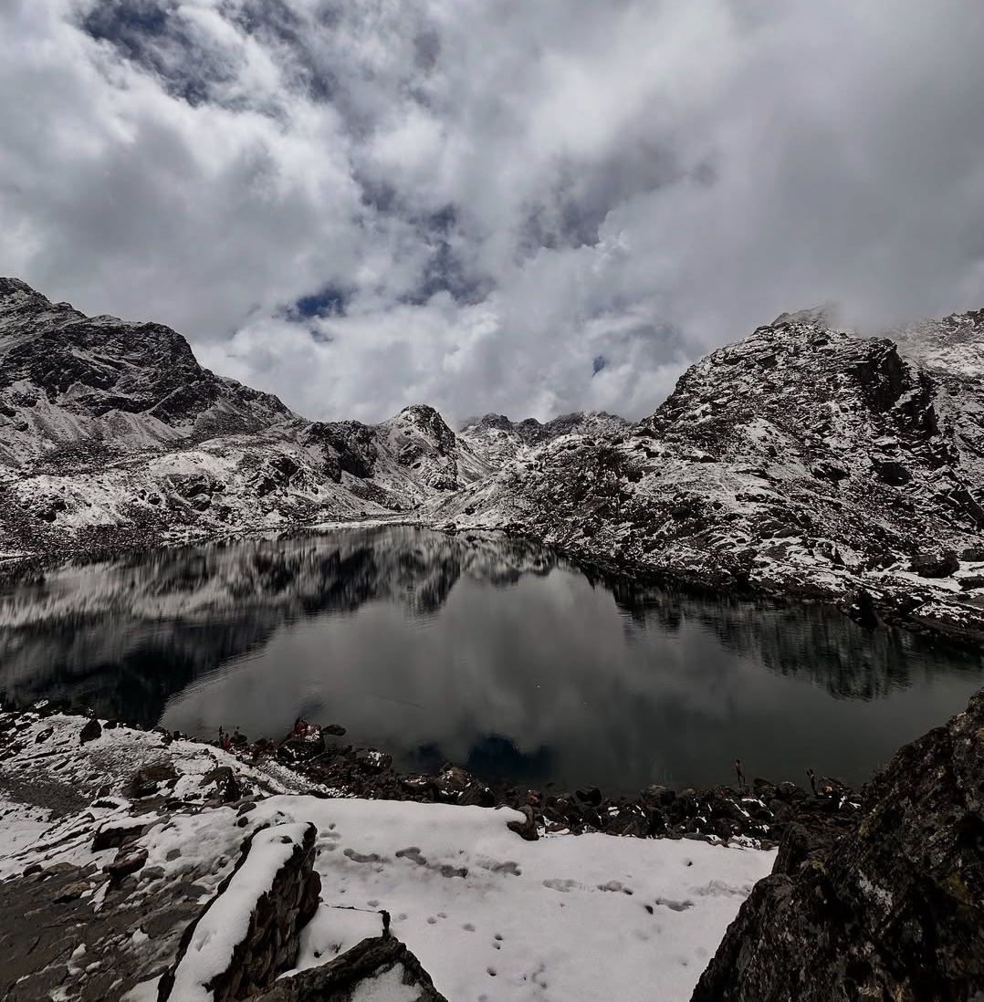 An alpine freshwater lake at high altitude surrounded by rocky mountain ridges.