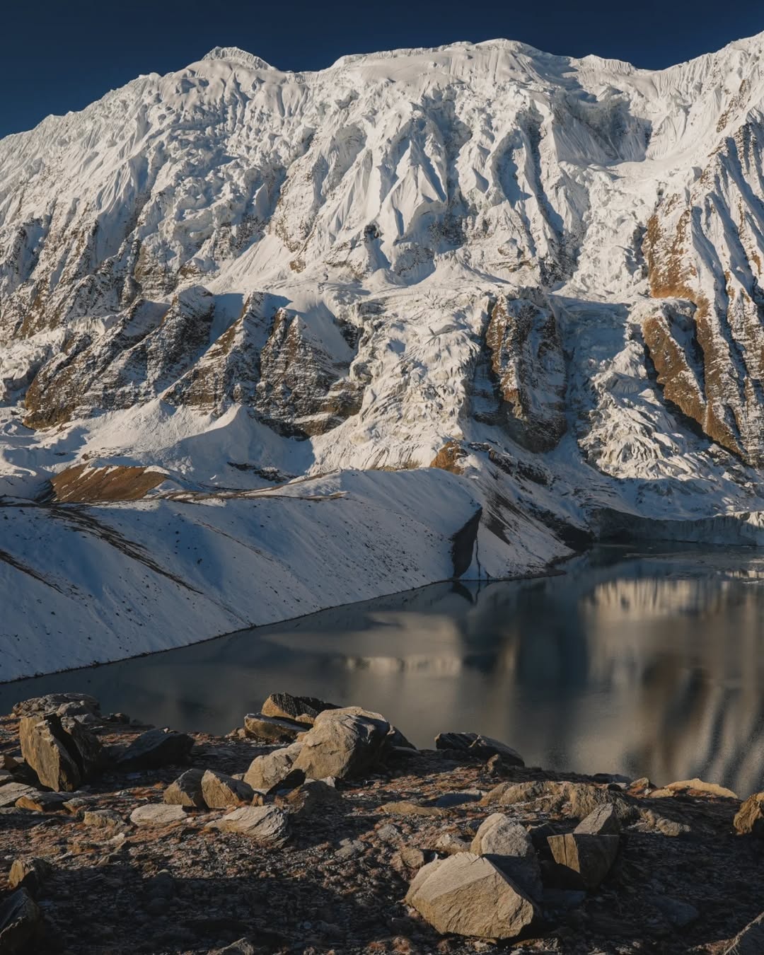 The deep turquoise waters of Tilicho Lake situated at the base of Tilicho Peak